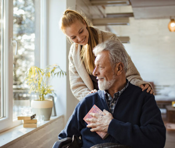 Close up of a granddaughter helping her grandfather around the house