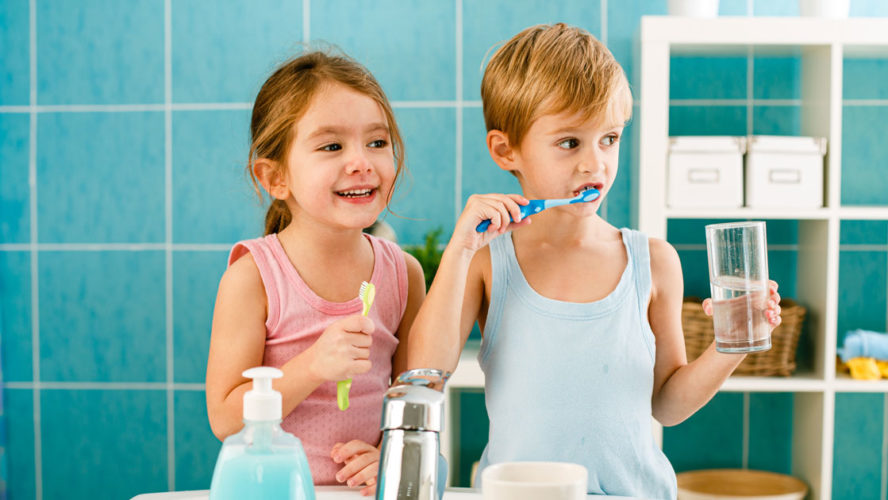 Sibling brushing their teeth in the bathroom together