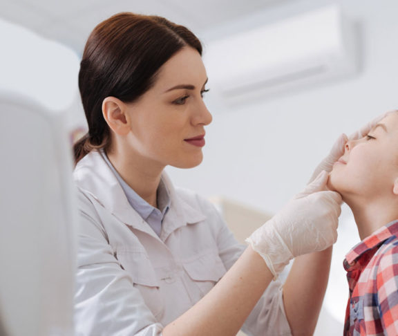 Attentive ENT doctor doing nose exam of her daughter