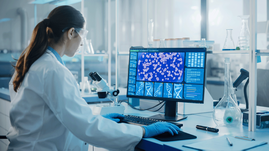 Microbiologist Working on Computer with Display Showing Gene Editing Interface.