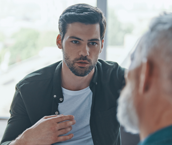 Handsome young man talking to his senior father