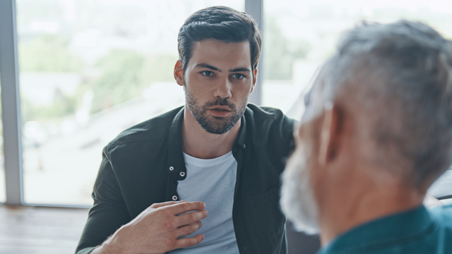 Handsome young man talking to his senior father