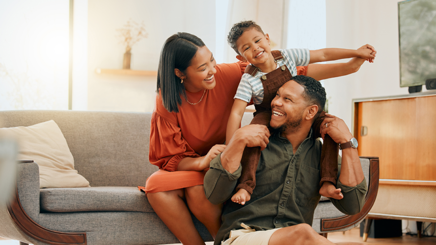 family of three relaxing in the lounge and being playful together.